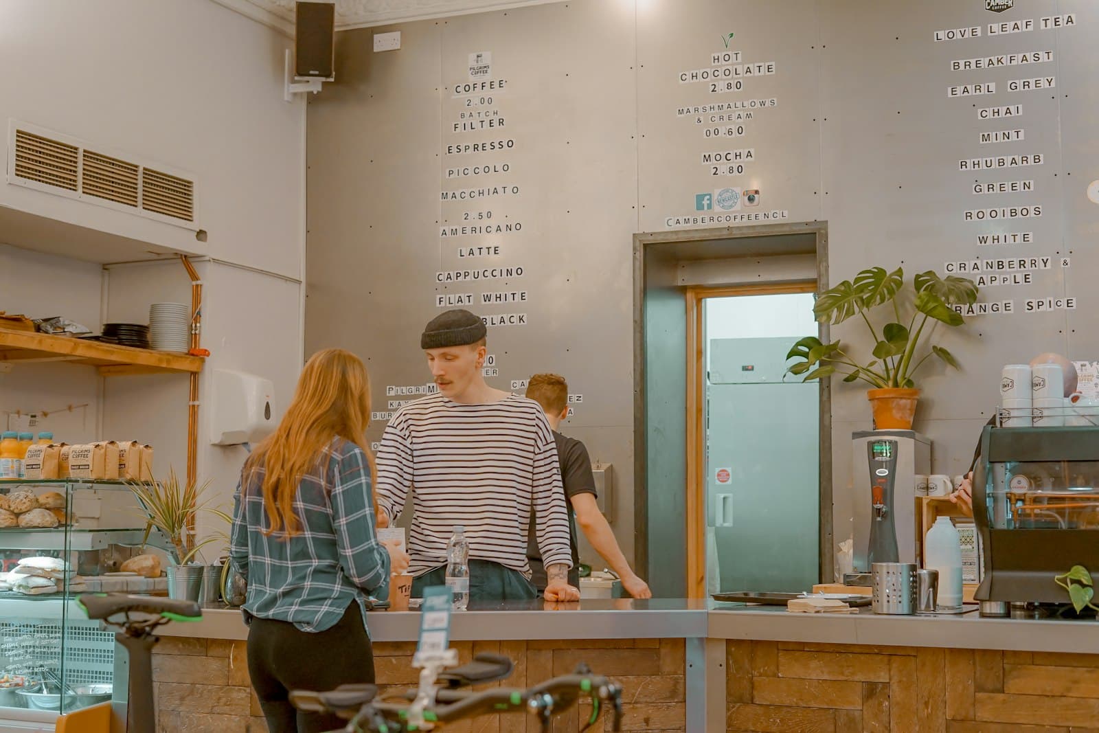 Two people in conversation at an independent coffee shop counter